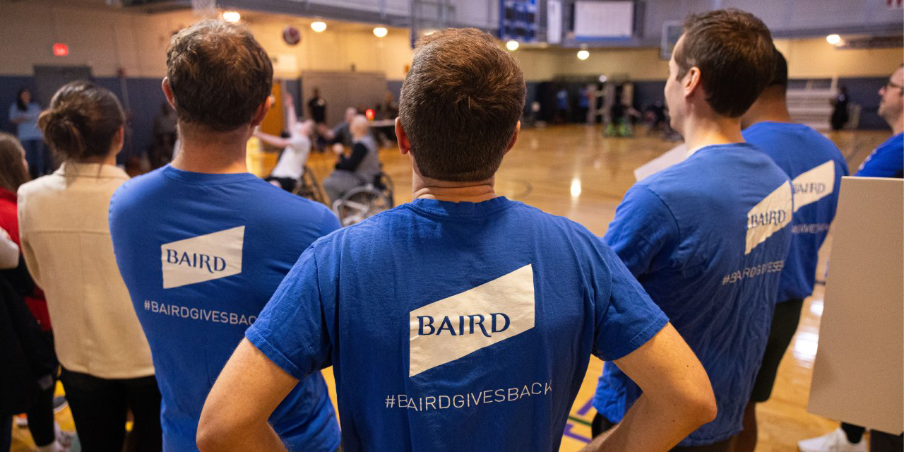 Baird associates watching a wheelchair basketball game.