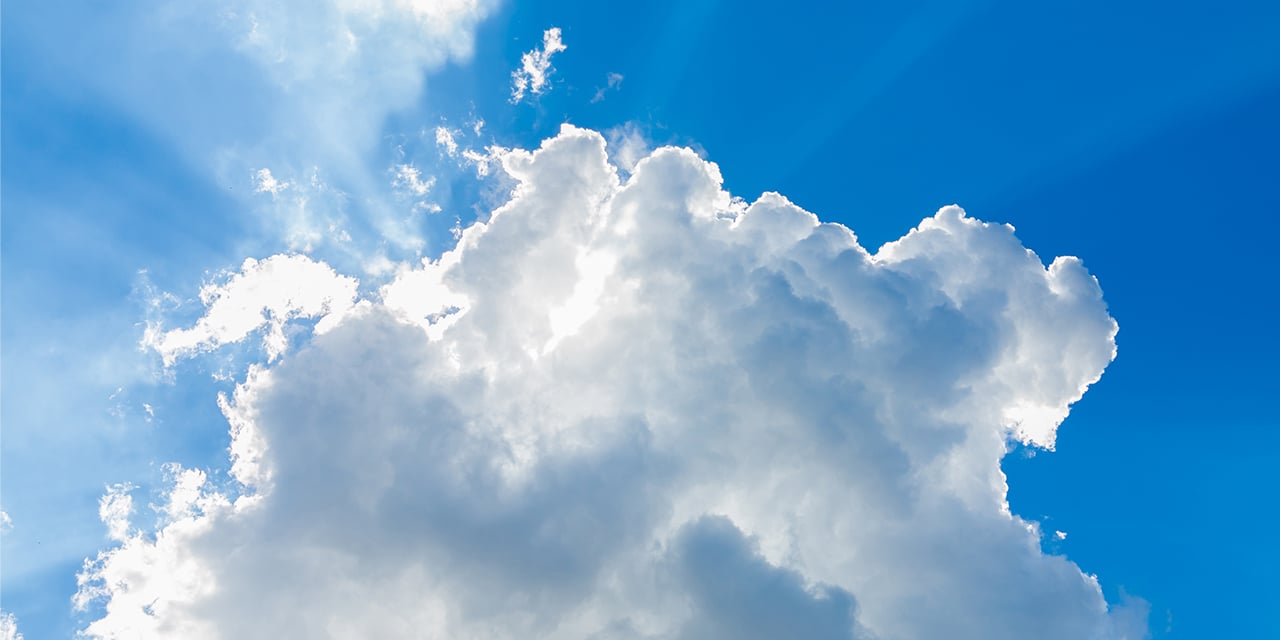 Blue sky with light streaming through the clouds