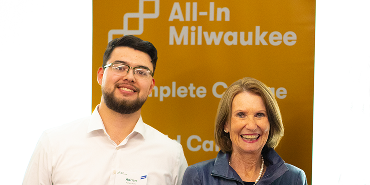 Mary Ellen Stanek standing with student in front of All-In Milwaukee banner.