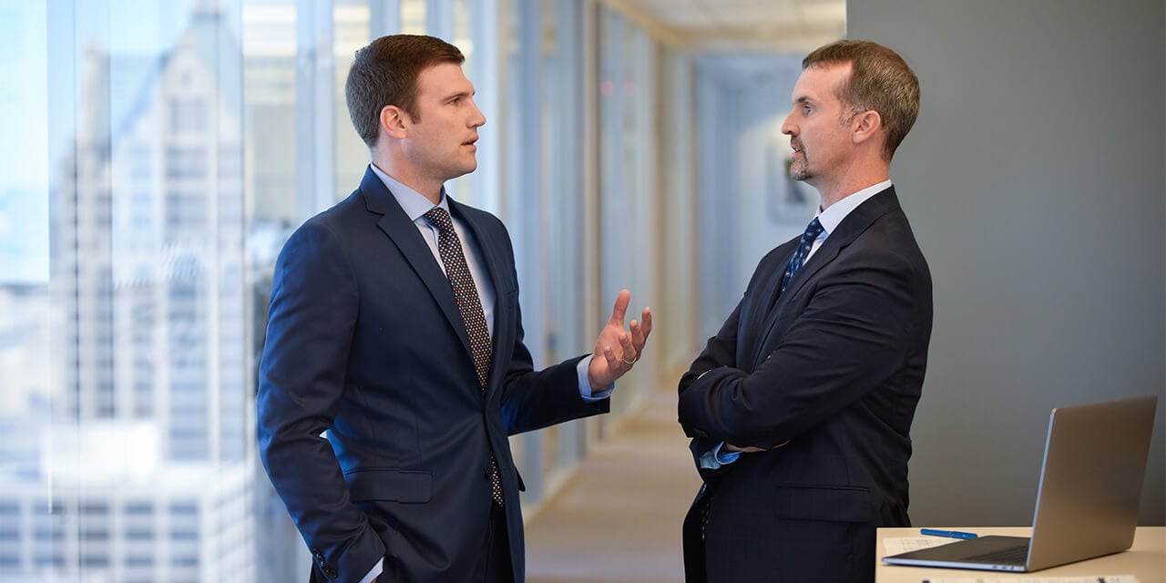 Two Asset Management associates having a conversation in an office setting
