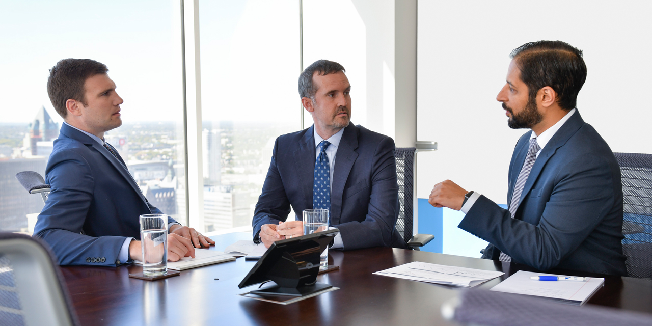 Baird Equity Asset Management associates talking at a table in a conference room.