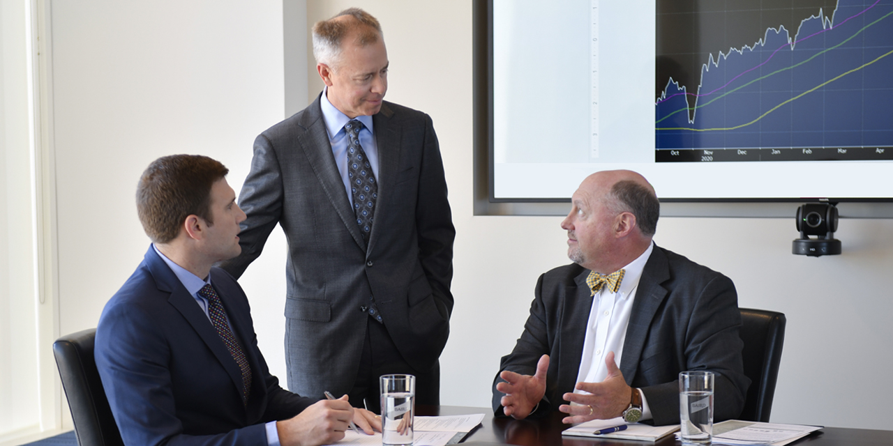 Three Baird Equity Asset Management professionals talking in a meeting.