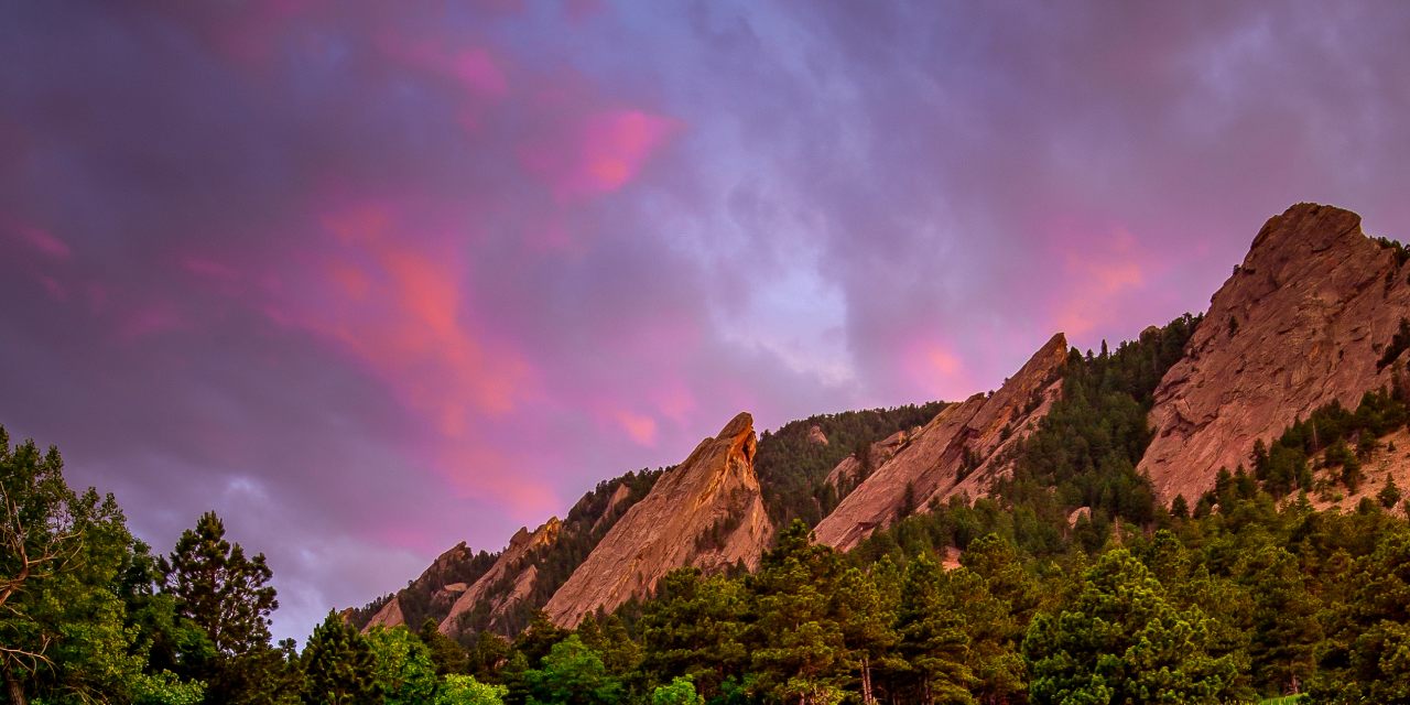 Mountain range with pink sky in background.