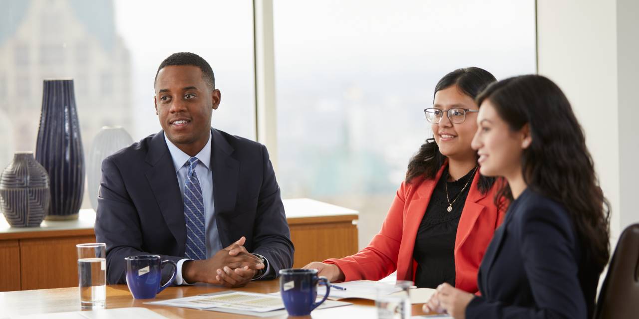 Three Baird associates sitting at a conference table